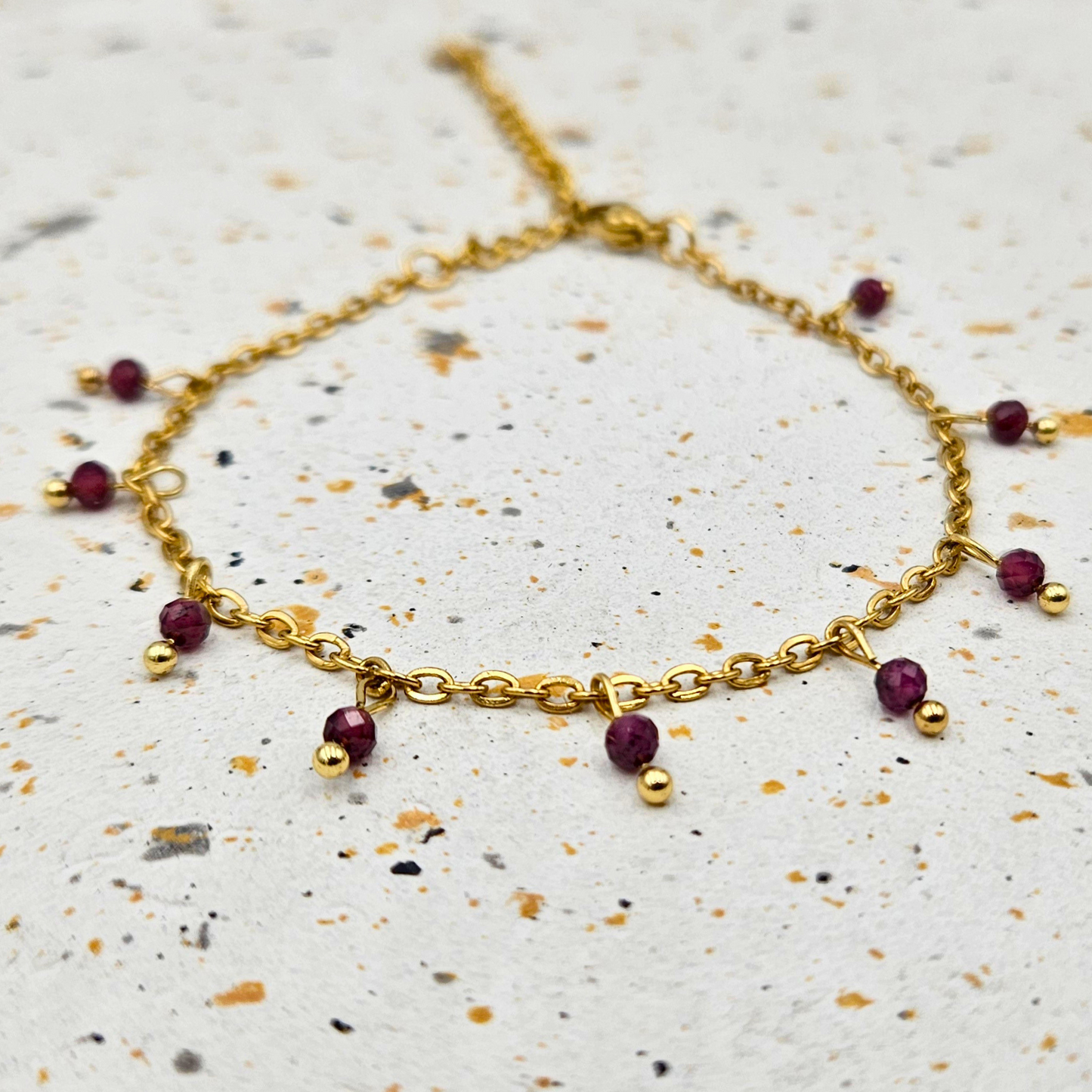 Armband van goldplated stainless steel met facetgeslepen granaat
