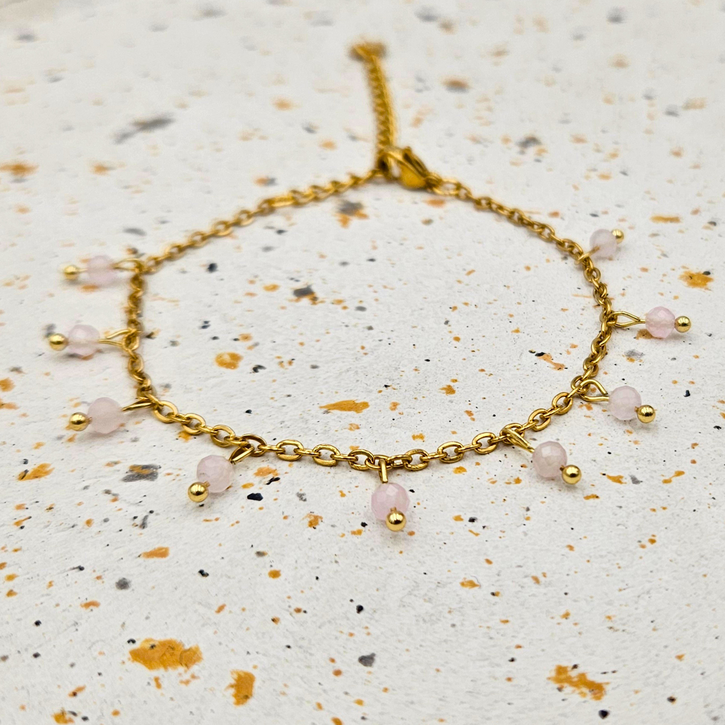 Armband van goldplated stainless steel met facetgeslepen rozenkwarts