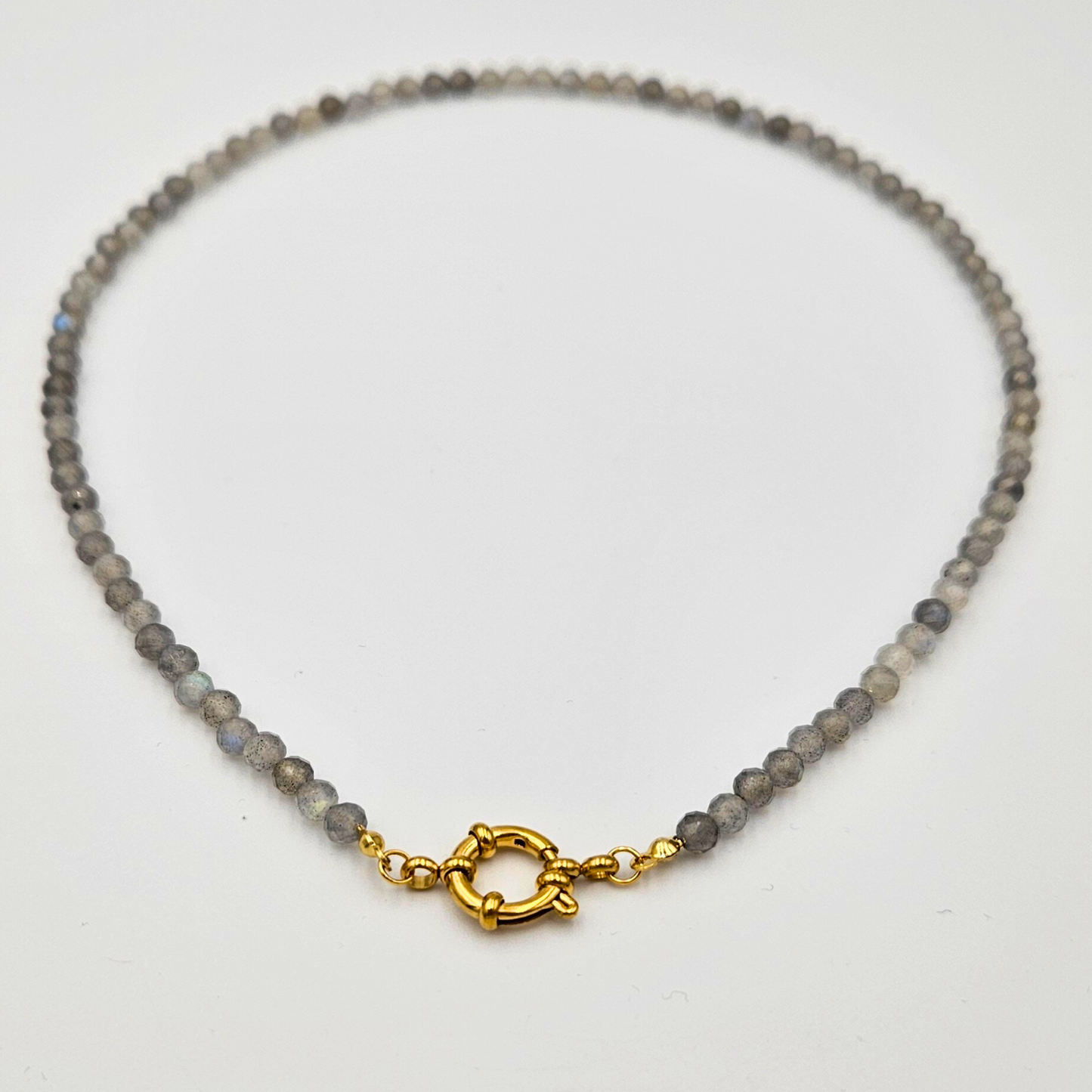 Ketting van facetgeslepen labradoriet afgewerkt met een boeisluiting van goldplated stainless steel