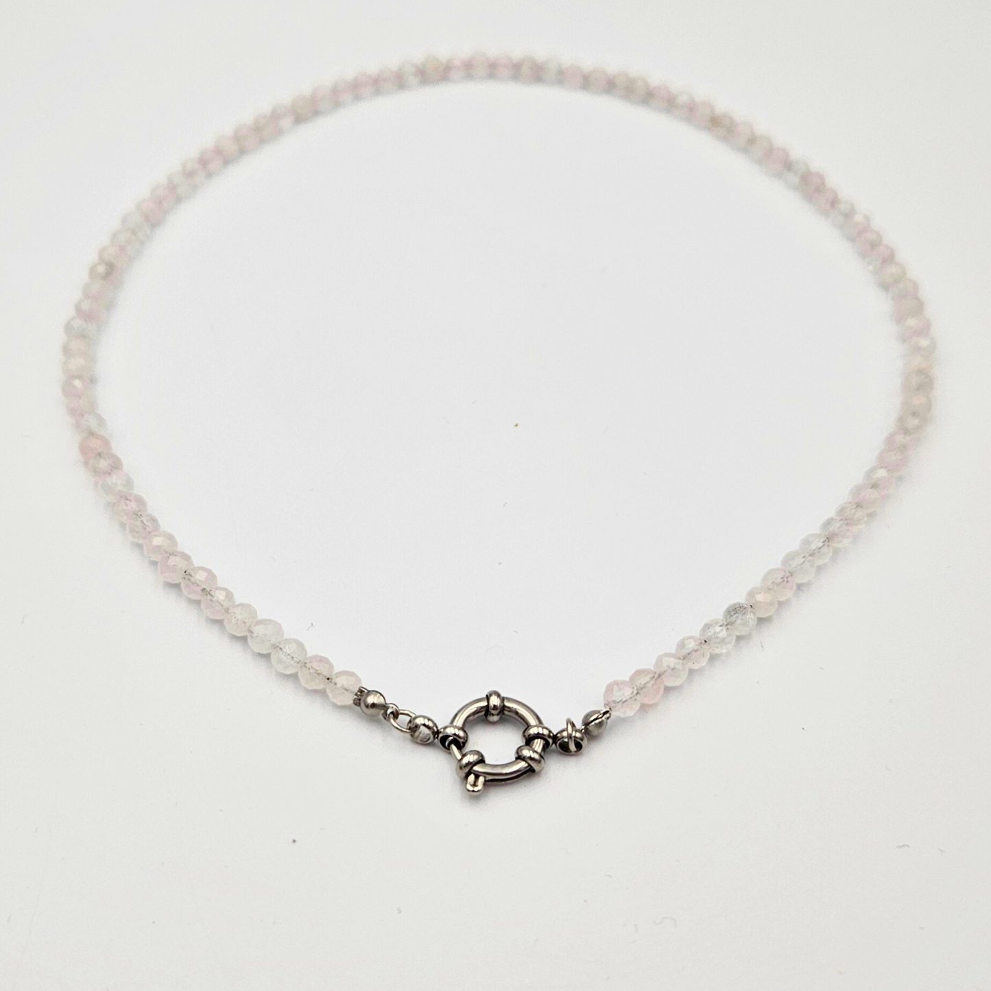 Ketting van facetgeslepen rozenkwarts afgewerkt met een boeisluiting van zilverkleurig stainless steel