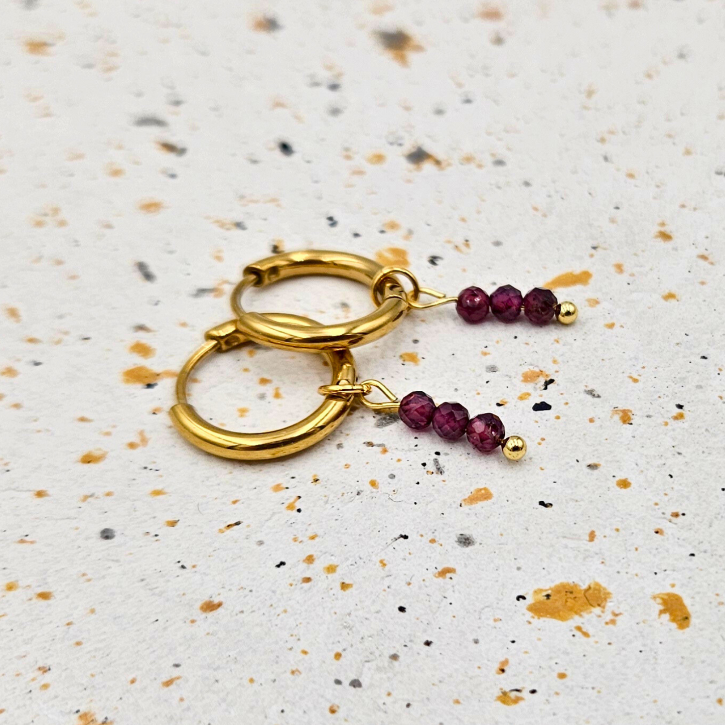 Oorbellen van goldplated stainless steel met facetgeslepen granaat