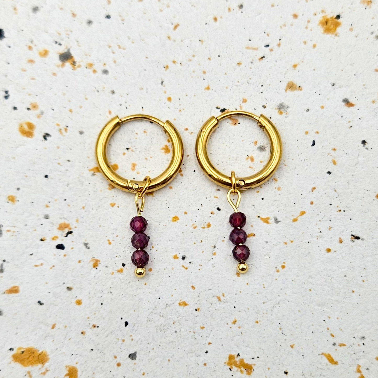 Oorbellen van goldplated stainless steel met facetgeslepen granaat