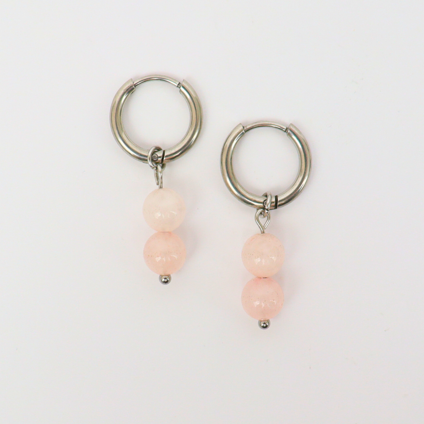 Oorbellen gemaakt van stainless steel met hanger van ronde rozenkwarts kralen