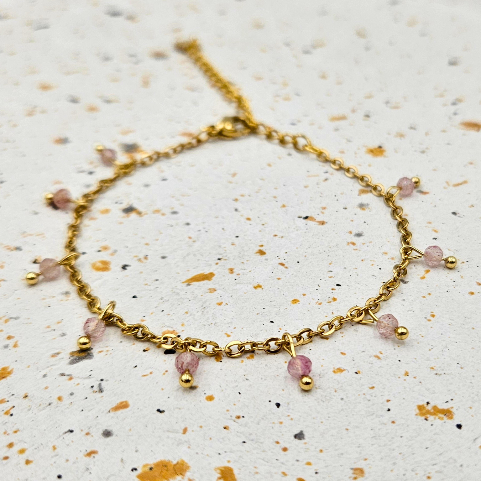 Armband van goldplated stainless steel met facetgeslepen aardbeienkwarts