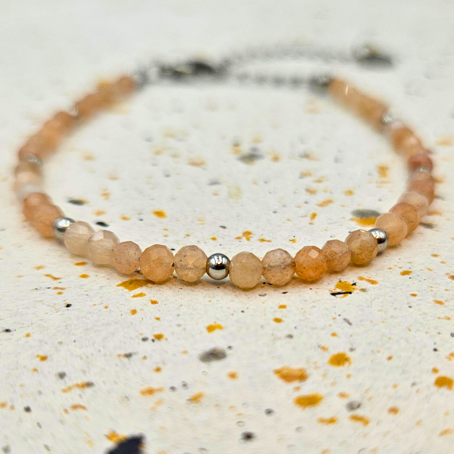 Armband van facetgeslepen zonnesteen afgewerkt met zilverkleurig stainless steel