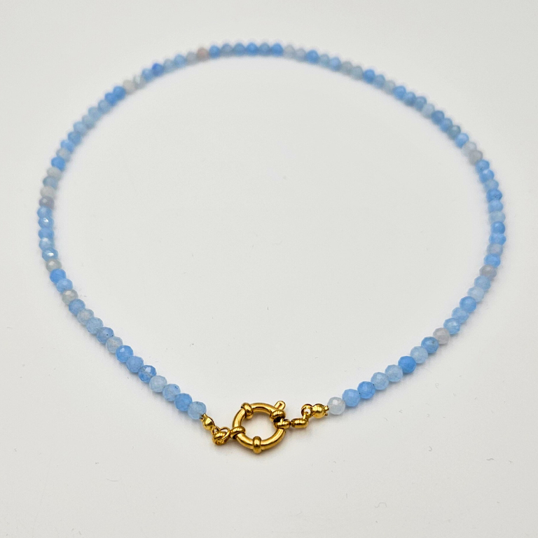 Ketting met facetgeslepen aquamarijn afgewerkt met een boeisluiting van goldplated stainless steel