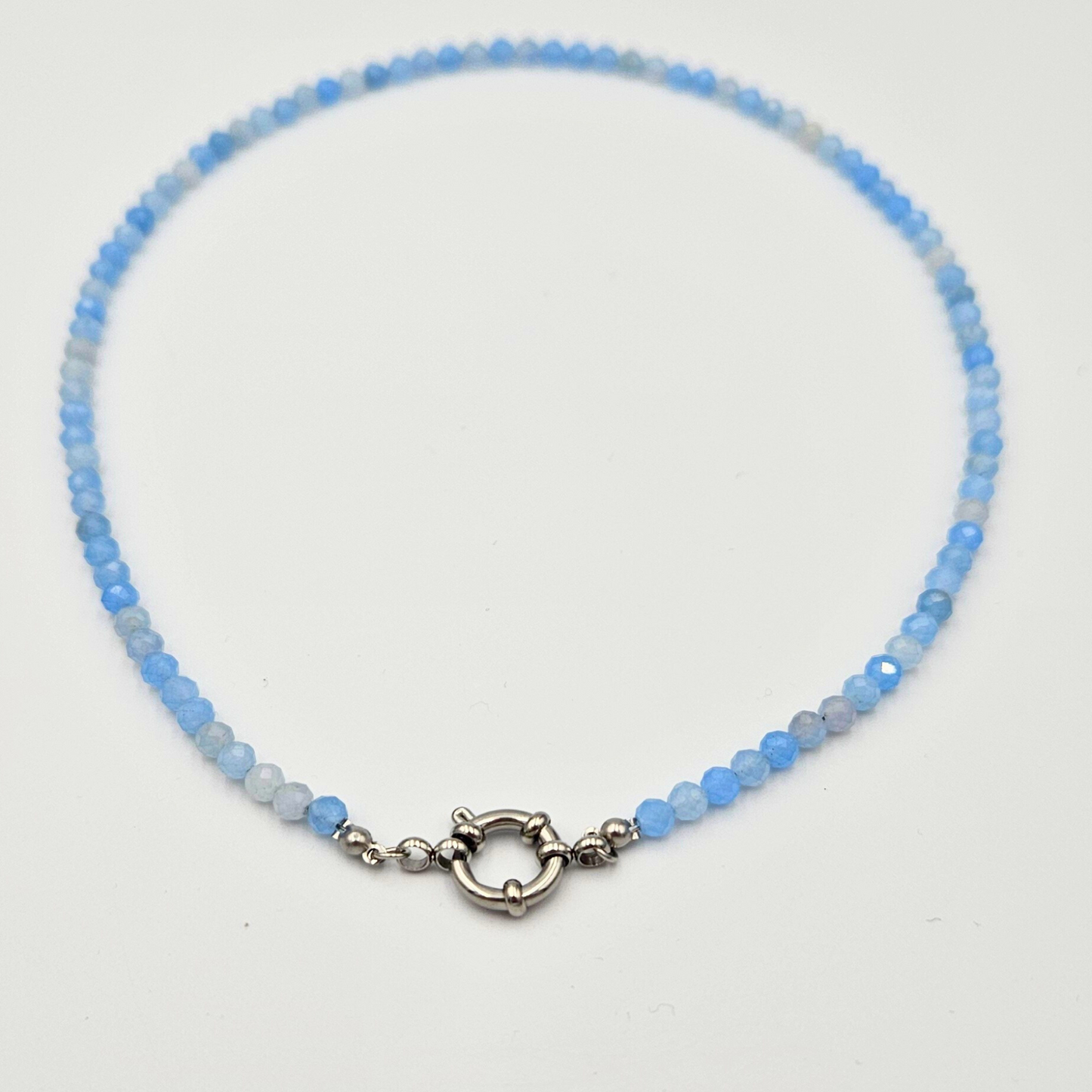 Ketting van facetgeslepen aquamarijn afgewerkt met boeisluiting van zilverkleurig stainless steel