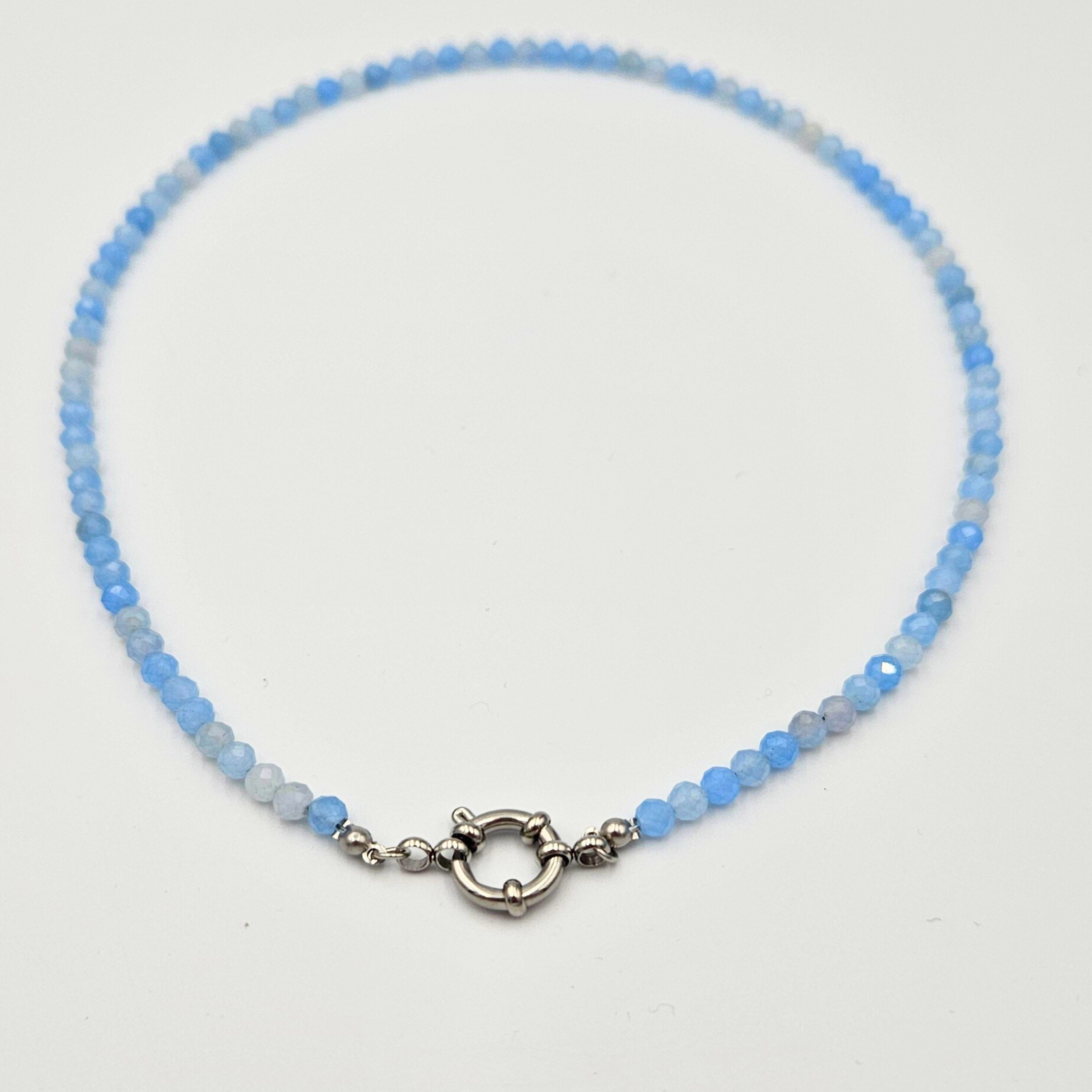 Ketting van facetgeslepen aquamarijn afgewerkt met boeisluiting van zilverkleurig stainless steel
