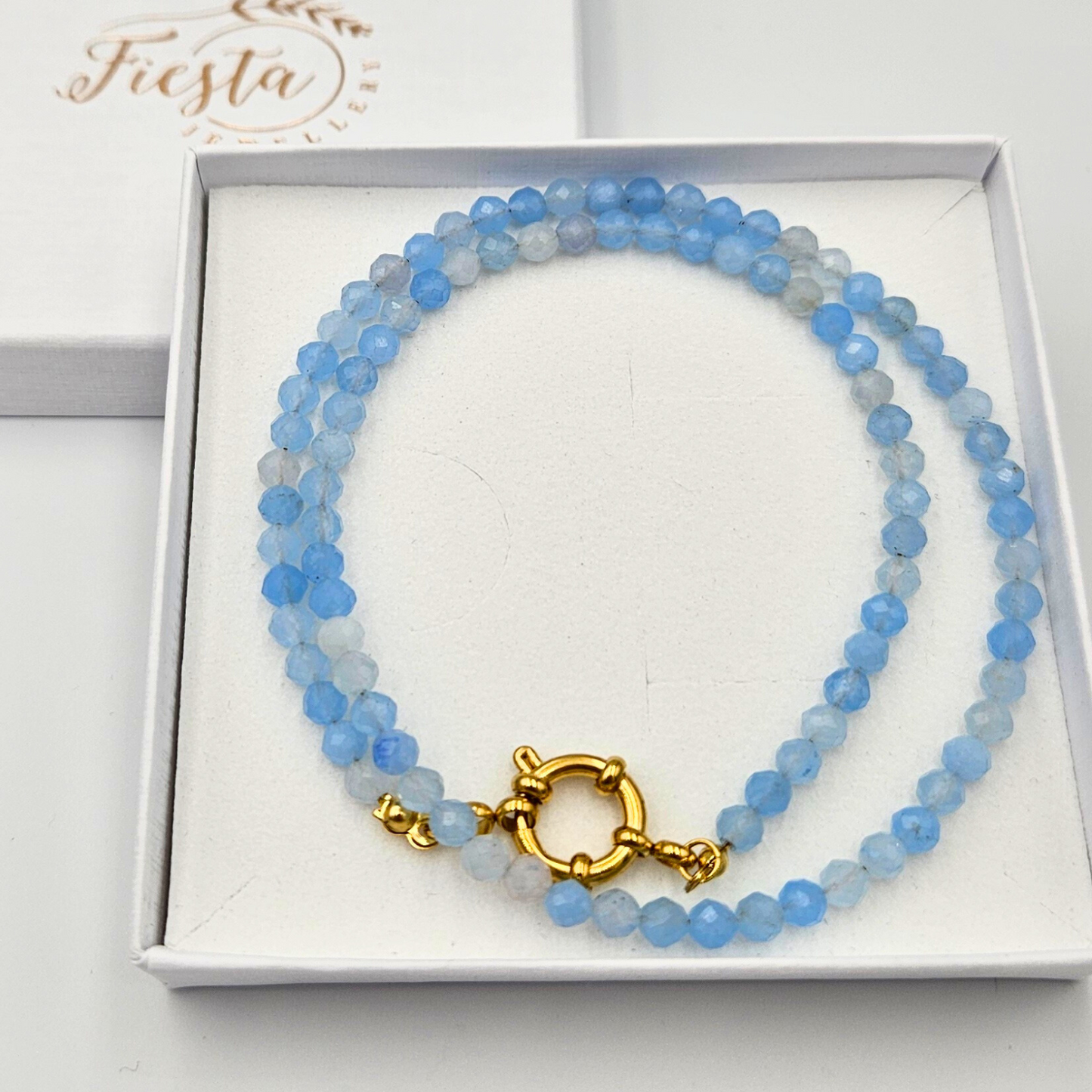 Ketting met facetgeslepen aquamarijn afgewerkt met een boeisluiting van goldplated stainless steel