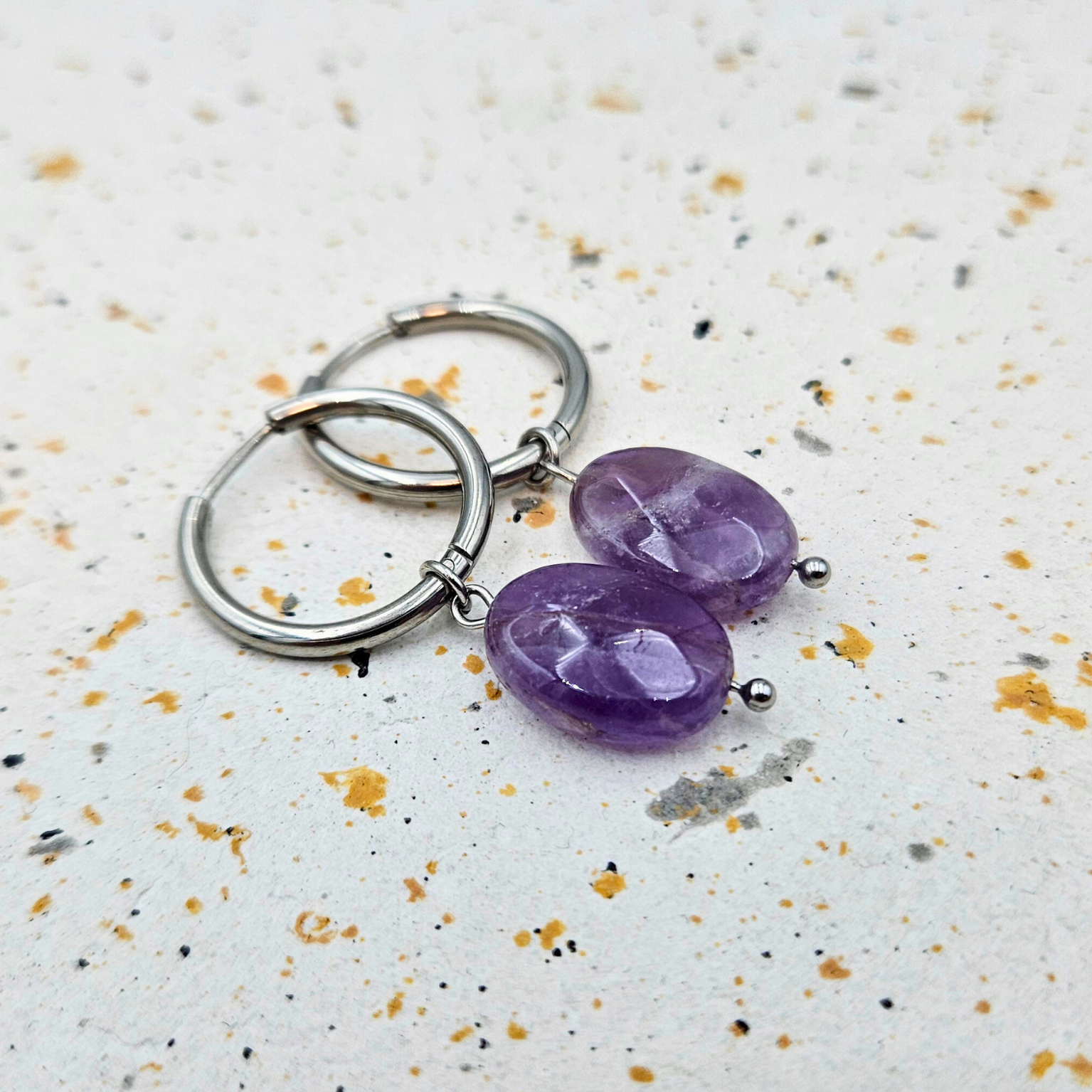 Oorbellen gemaakt van stainless steel met facetgeslepen amethist hanger