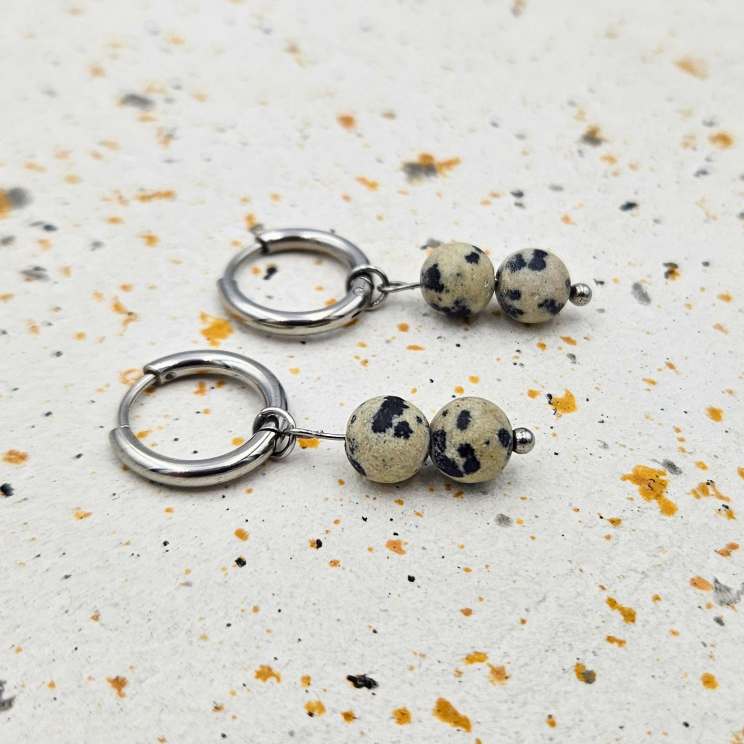 Oorbellen gemaakt van stainless steel met hanger van ronde dalmatiër jaspis