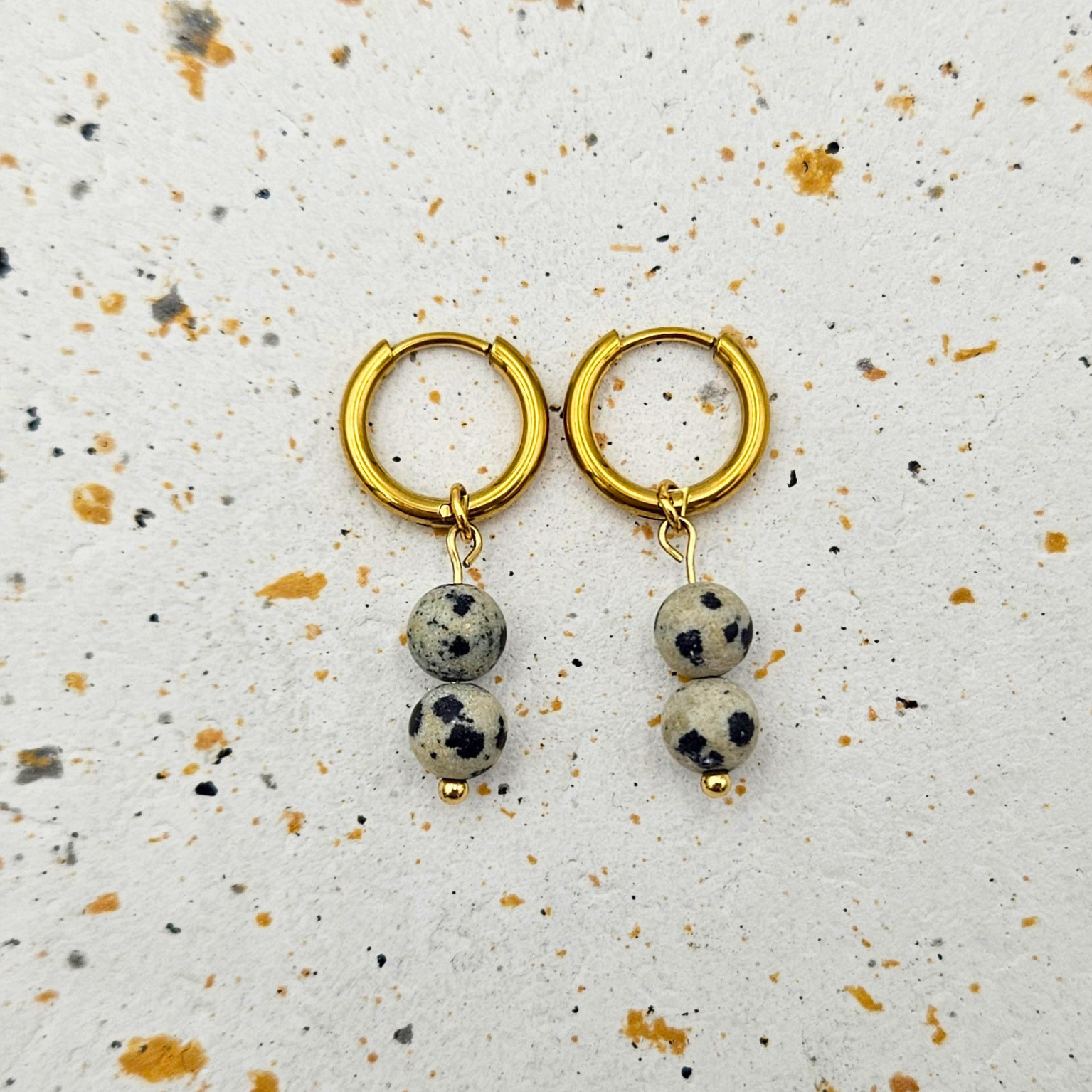 Oorbellen van goldplated stainless steel met hanger van ronde dalmatiër jaspis