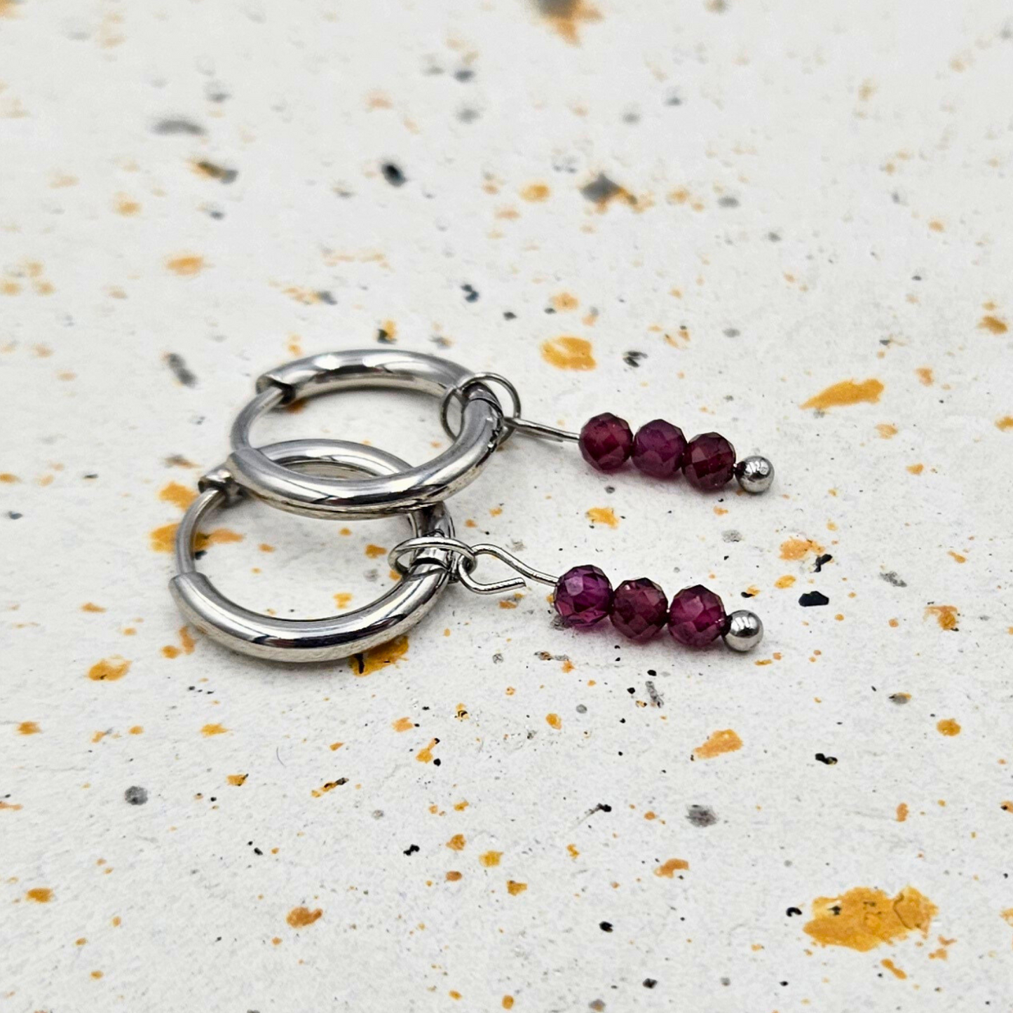 Oorbellen gemaakt van stainless steel met facetgeslepen granaat