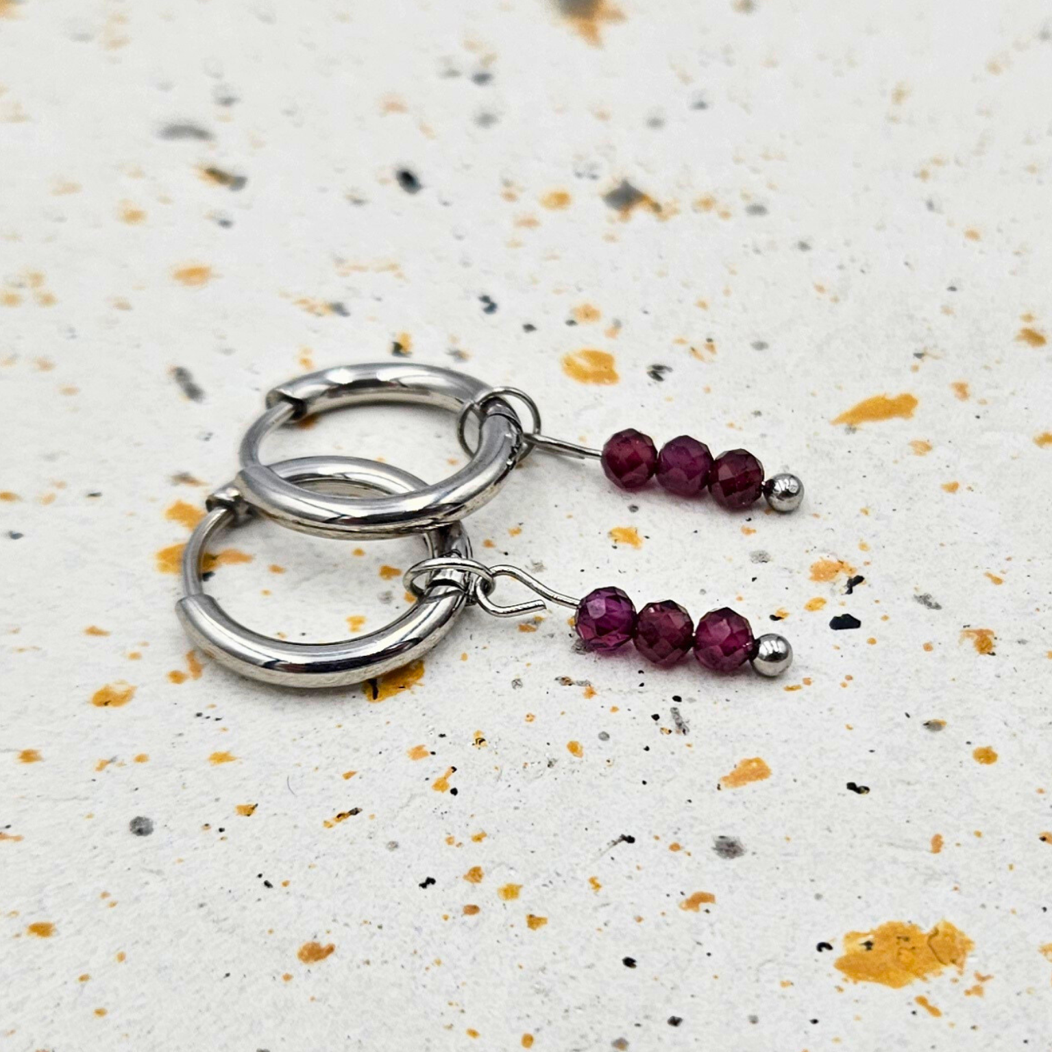 Oorbellen gemaakt van stainless steel met facetgeslepen granaat