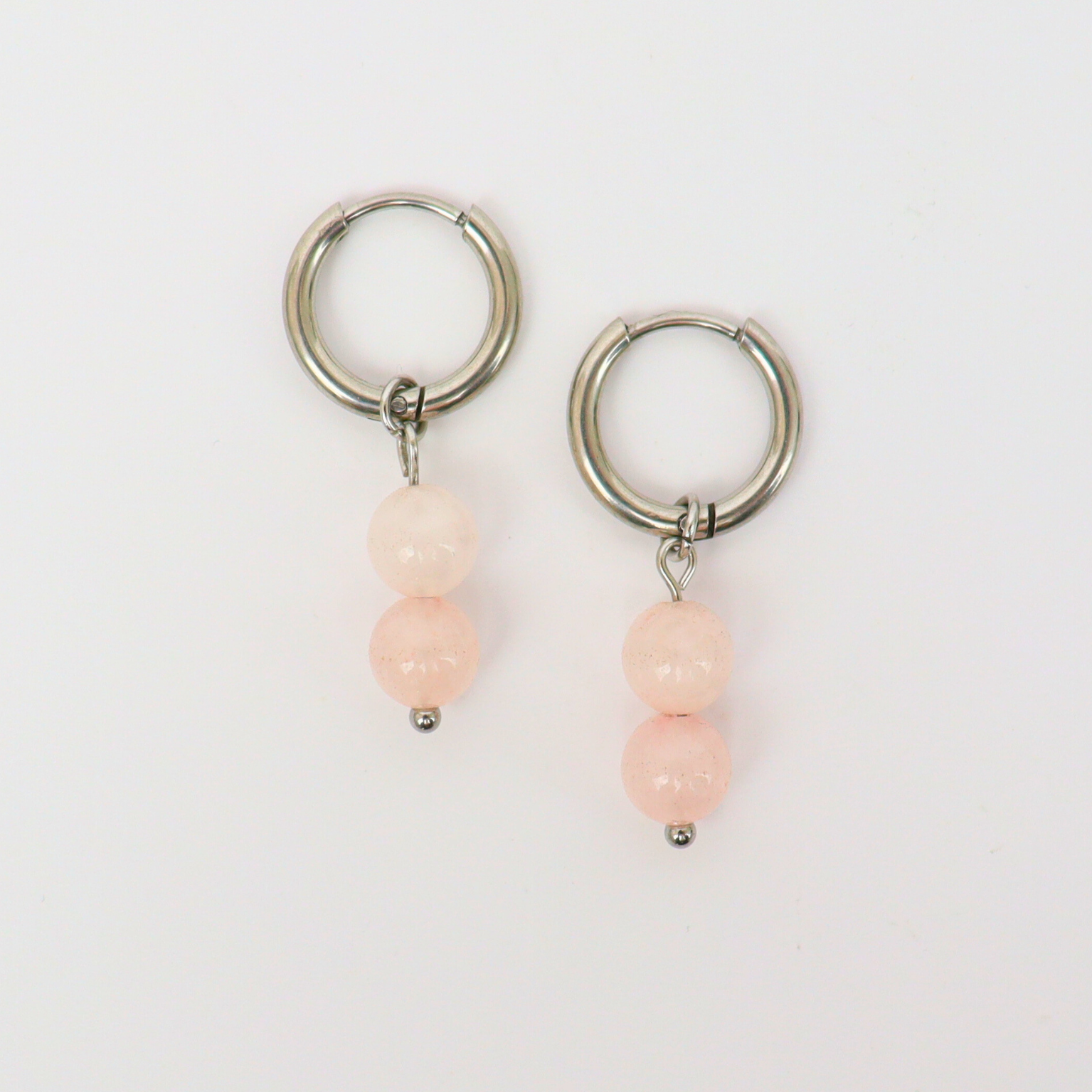 Oorbellen gemaakt van stainless steel met hanger van ronde rozenkwarts kralen
