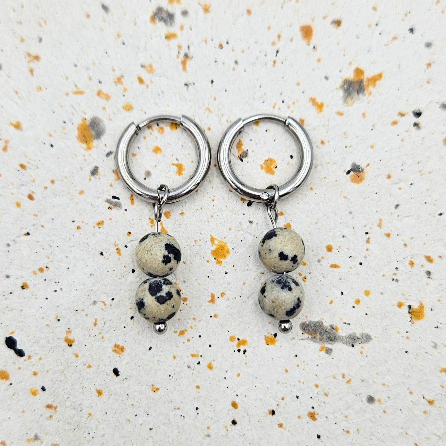 Oorbellen gemaakt van stainless steel met hanger van ronde dalmatiër jaspis